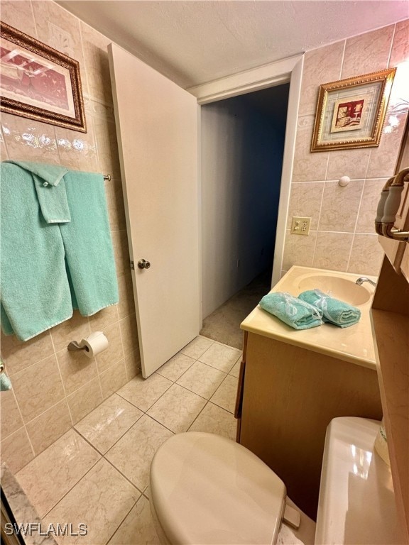 bathroom with tile patterned flooring, tile walls, and toilet