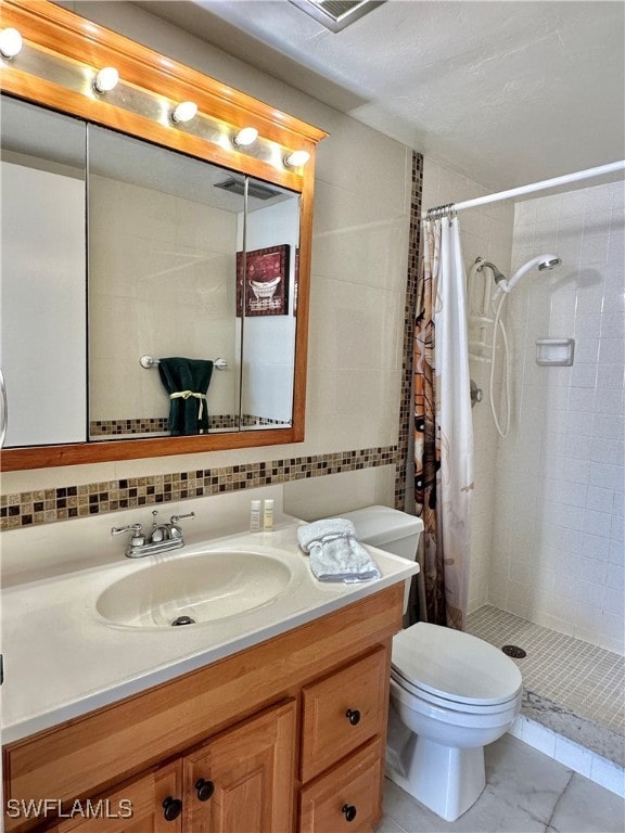 bathroom featuring tasteful backsplash, vanity, tile walls, and toilet