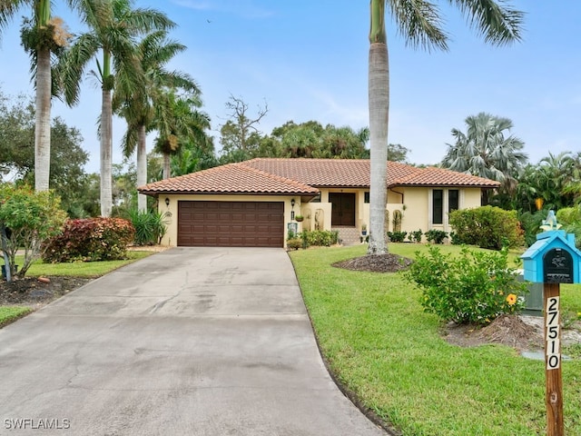 mediterranean / spanish house with a front lawn and a garage