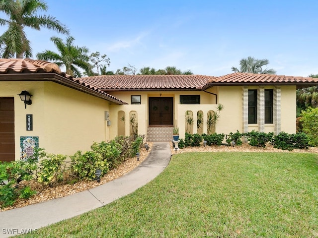 mediterranean / spanish home featuring a front lawn