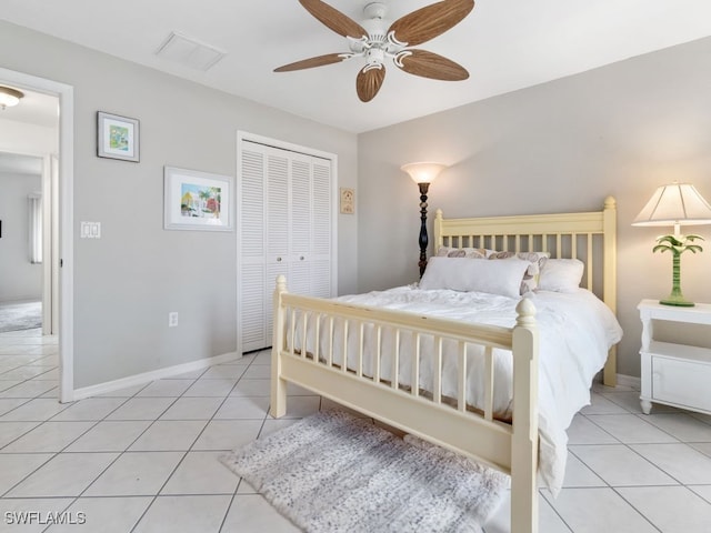 bedroom with ceiling fan, light tile patterned floors, and a closet