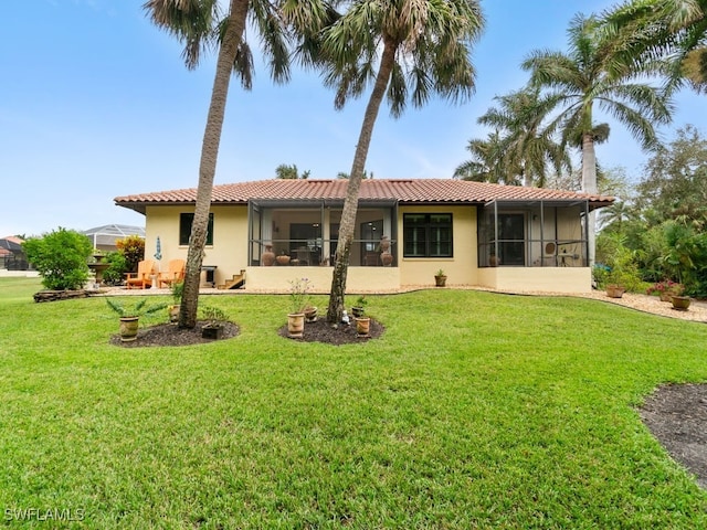 back of property featuring a sunroom and a yard