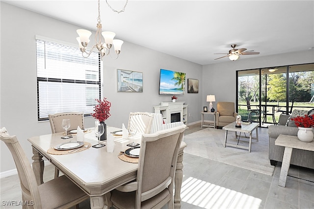 dining space with ceiling fan with notable chandelier and plenty of natural light