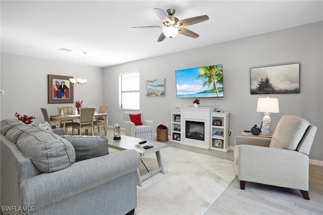 living room with ceiling fan with notable chandelier