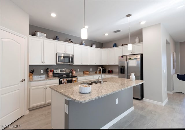 kitchen featuring stainless steel appliances, white cabinets, sink, and pendant lighting