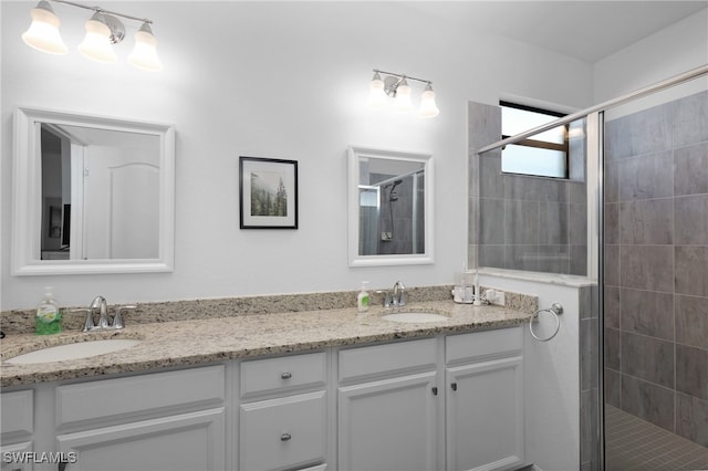 bathroom featuring a shower with door and vanity