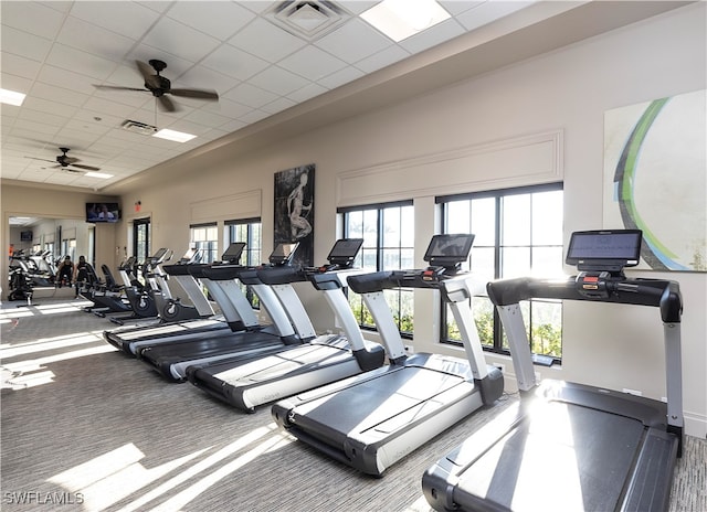 gym with a paneled ceiling and ceiling fan