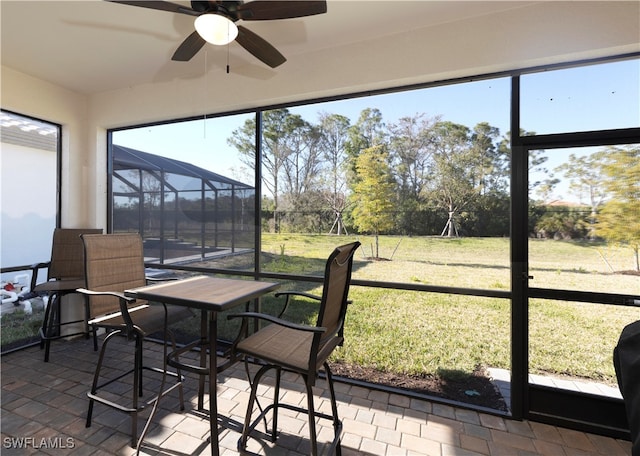 sunroom / solarium featuring ceiling fan