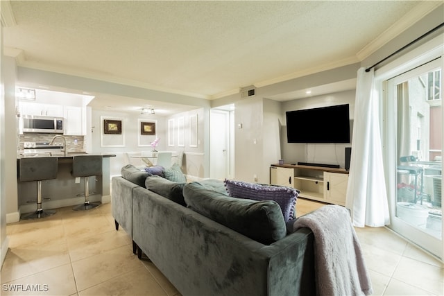 tiled living room with ornamental molding and a textured ceiling