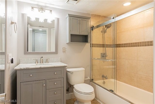 full bathroom featuring vanity, bath / shower combo with glass door, and toilet