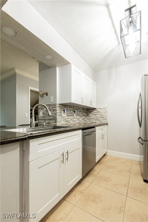 kitchen with white cabinets, light tile patterned floors, and stainless steel appliances