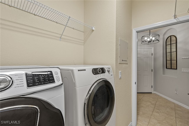 clothes washing area with electric panel, an inviting chandelier, light tile patterned floors, and separate washer and dryer