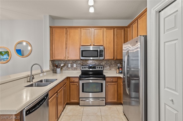 kitchen featuring light tile patterned floors, sink, backsplash, and appliances with stainless steel finishes