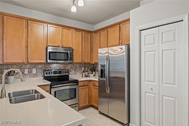 kitchen featuring stainless steel appliances, light tile patterned floors, sink, and tasteful backsplash