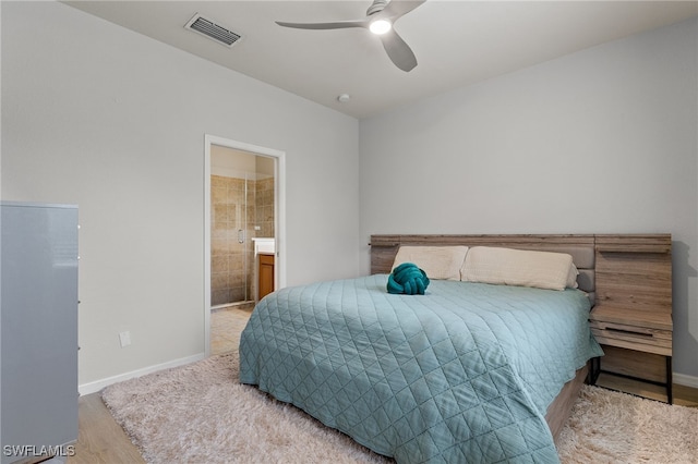 bedroom featuring hardwood / wood-style flooring, ceiling fan, and ensuite bath