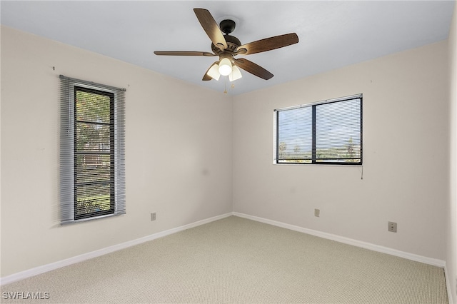 carpeted spare room featuring ceiling fan