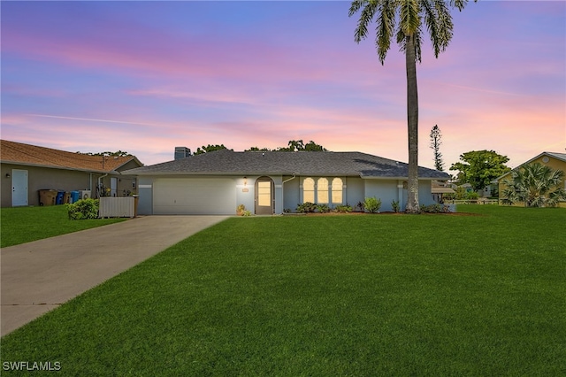 single story home with a garage and a yard