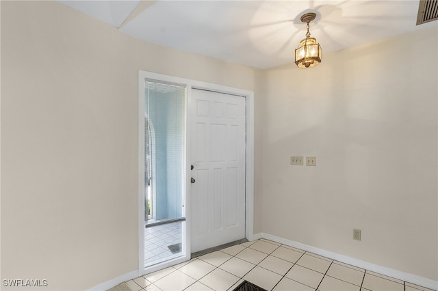 tiled entrance foyer featuring a notable chandelier