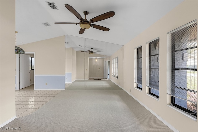 carpeted spare room featuring lofted ceiling and ceiling fan