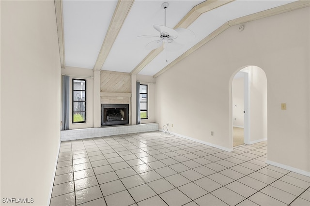 unfurnished living room with high vaulted ceiling, a fireplace, light tile patterned floors, and beam ceiling