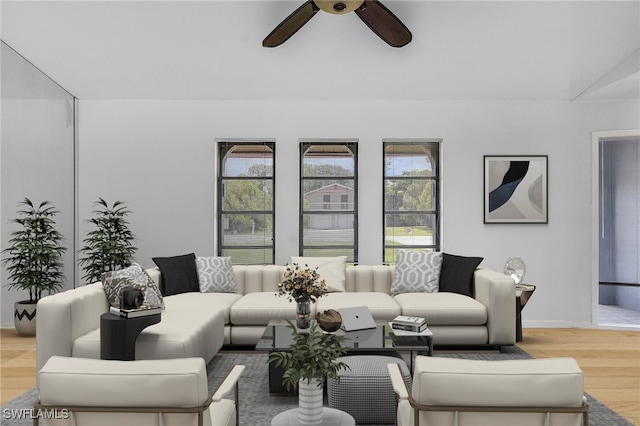 living room featuring ceiling fan, lofted ceiling, and light hardwood / wood-style floors