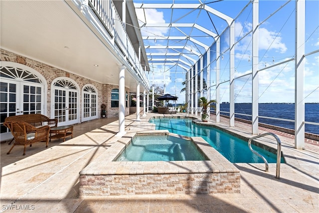 view of swimming pool featuring a patio, glass enclosure, an in ground hot tub, and a water view