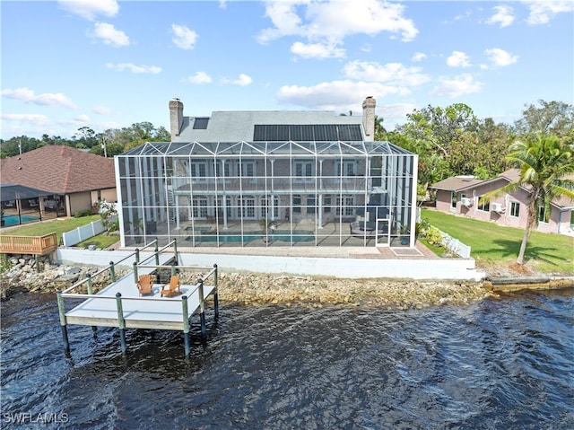 rear view of house featuring a water view, glass enclosure, and a pool