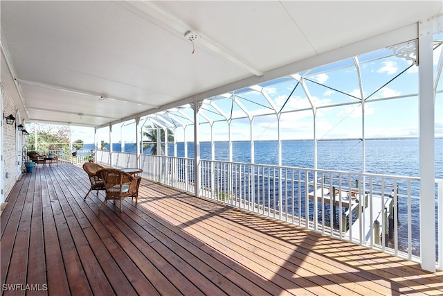 deck featuring glass enclosure and a water view