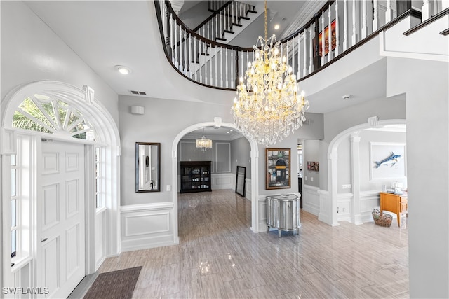 foyer entrance featuring a notable chandelier and a towering ceiling