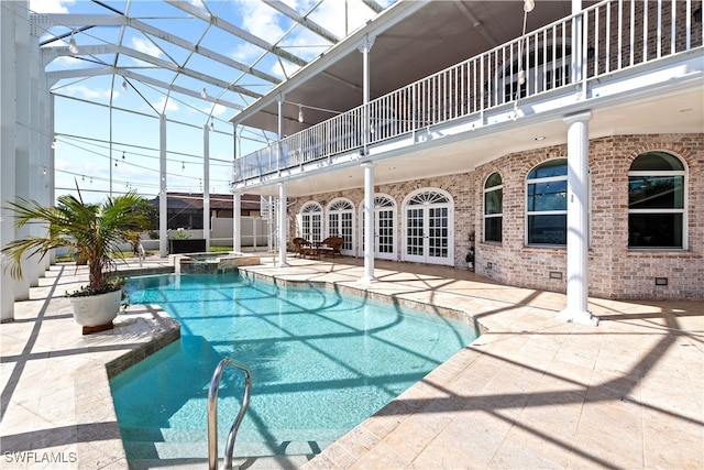 view of pool with french doors, glass enclosure, a patio, and an in ground hot tub