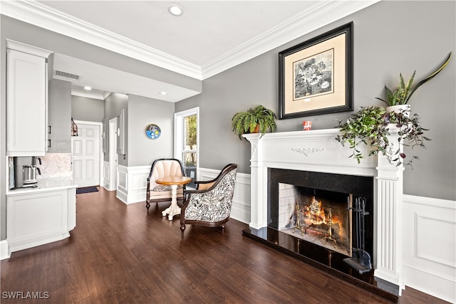 living area with dark hardwood / wood-style flooring and crown molding