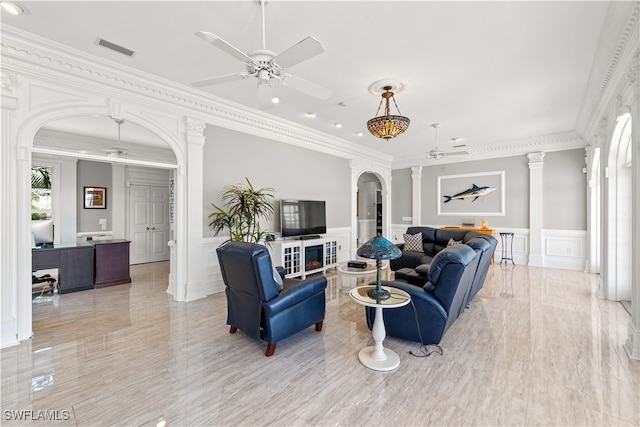 living room with ornamental molding, ceiling fan, and ornate columns