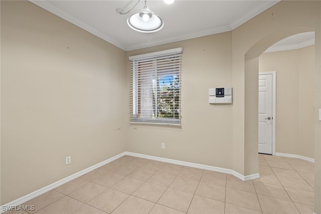 spare room featuring light tile patterned flooring and crown molding