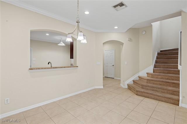 interior space with light tile patterned flooring and ornamental molding