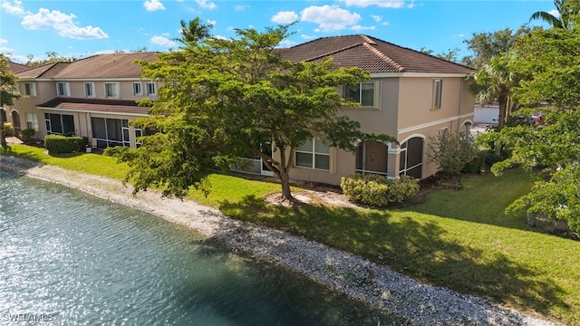 exterior space with a water view and a lawn