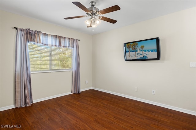 spare room featuring dark wood-type flooring and ceiling fan