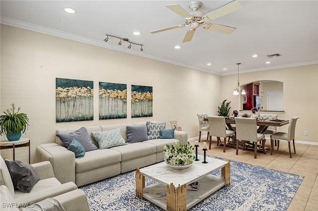 tiled living room with ceiling fan and crown molding