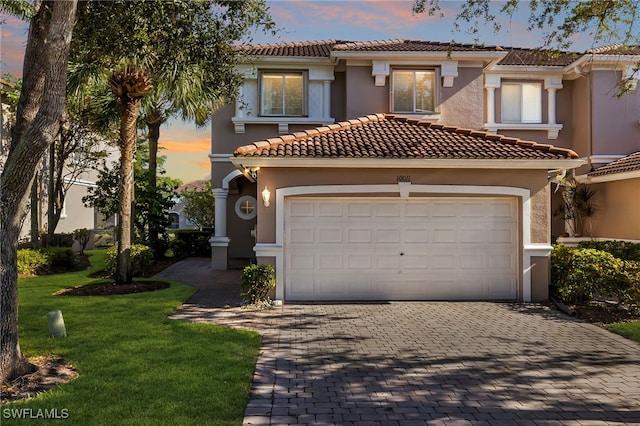 mediterranean / spanish house with a garage and a yard