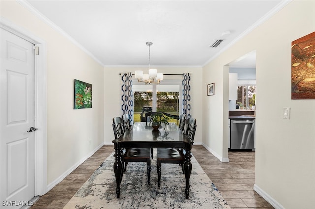 dining space featuring an inviting chandelier, a wealth of natural light, hardwood / wood-style floors, and crown molding