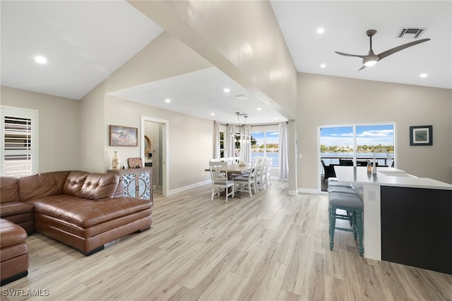 living room with light wood-type flooring, ceiling fan, and high vaulted ceiling