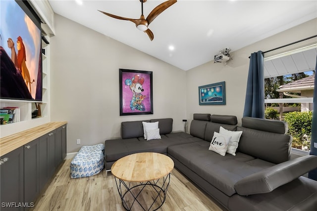 living room with light hardwood / wood-style floors, ceiling fan, and vaulted ceiling