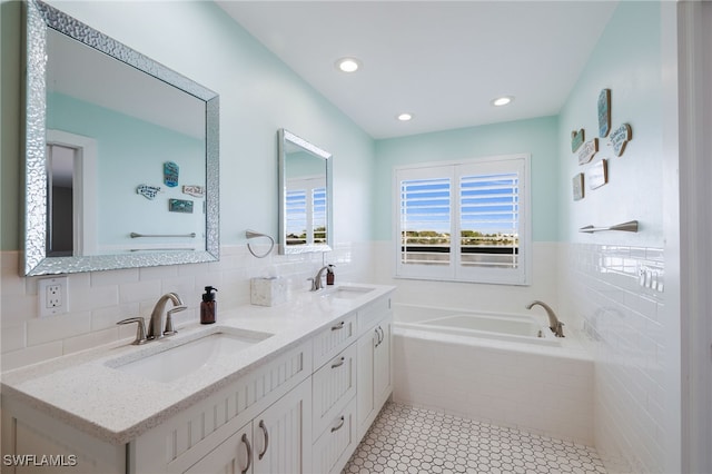 bathroom with a relaxing tiled tub, tile patterned flooring, and vanity