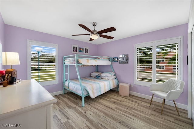 bedroom featuring light wood-type flooring, multiple windows, and ceiling fan