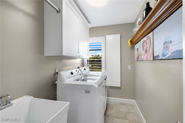 washroom with cabinets, sink, and washing machine and clothes dryer