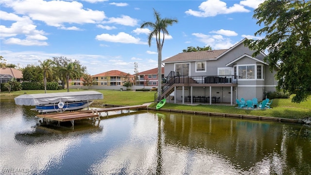 exterior space featuring a deck with water view and a lawn