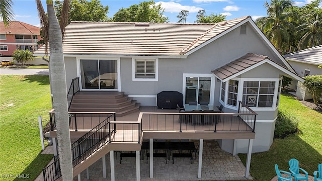 rear view of property with a deck, a yard, and a patio area