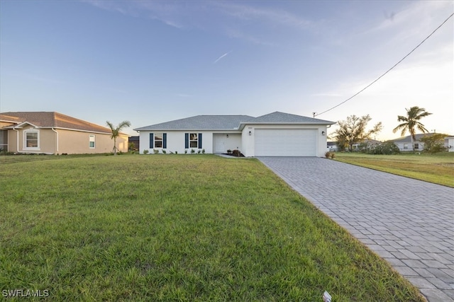 ranch-style house with a garage and a yard