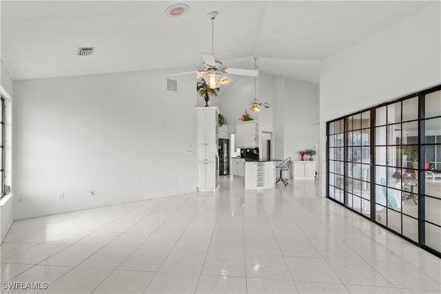 unfurnished living room featuring high vaulted ceiling, light tile patterned flooring, and ceiling fan