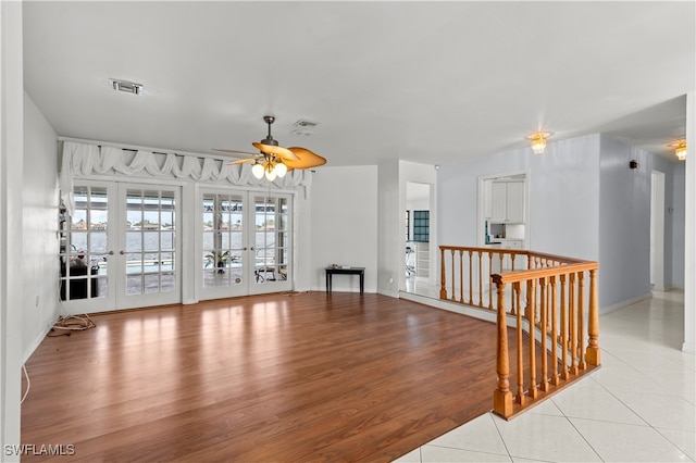 empty room featuring french doors, light hardwood / wood-style floors, and ceiling fan