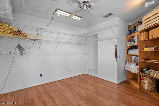 walk in closet with hardwood / wood-style flooring and ceiling fan